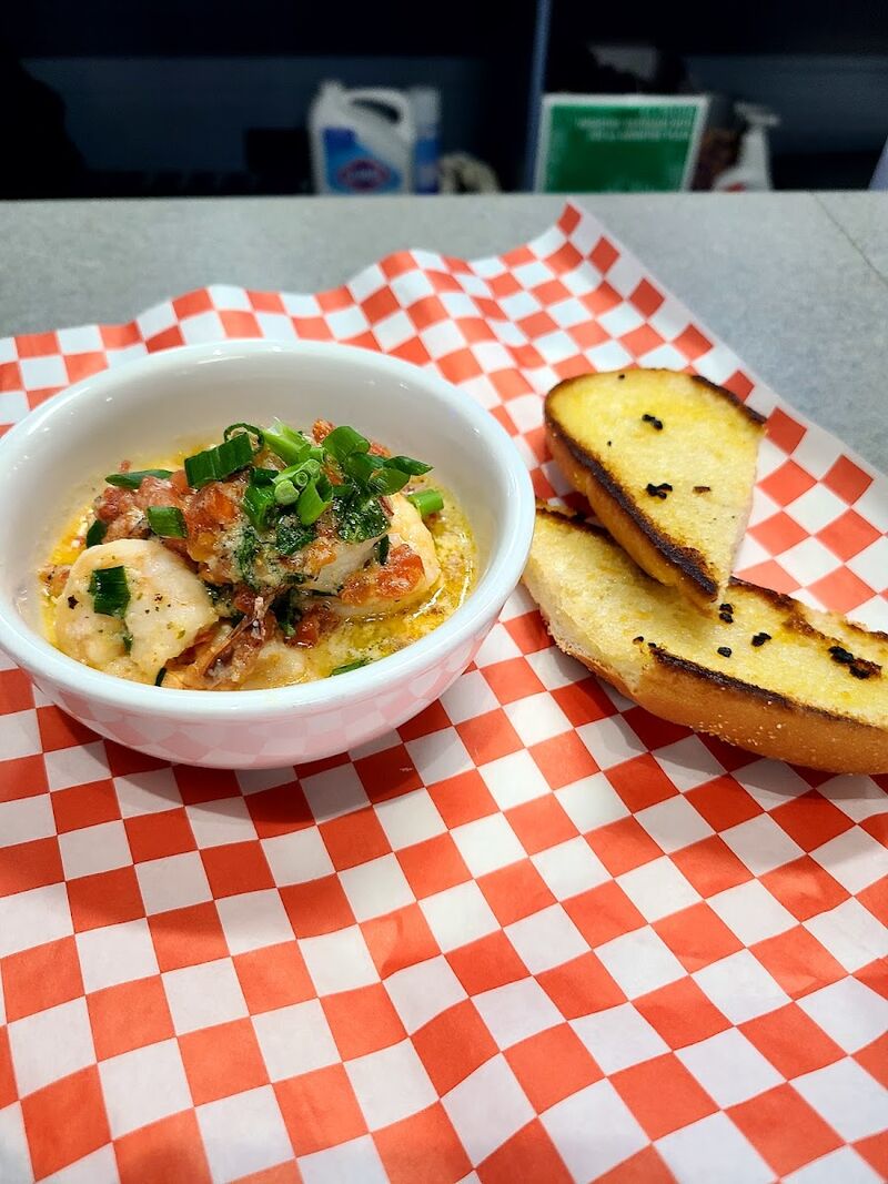 Sambuca prawns in a cream and tomato sauce, topped with green onion, with two slices of griddled garlic bread.